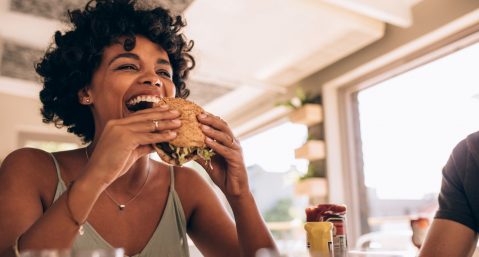 Woman eating a burger at a restaurant.