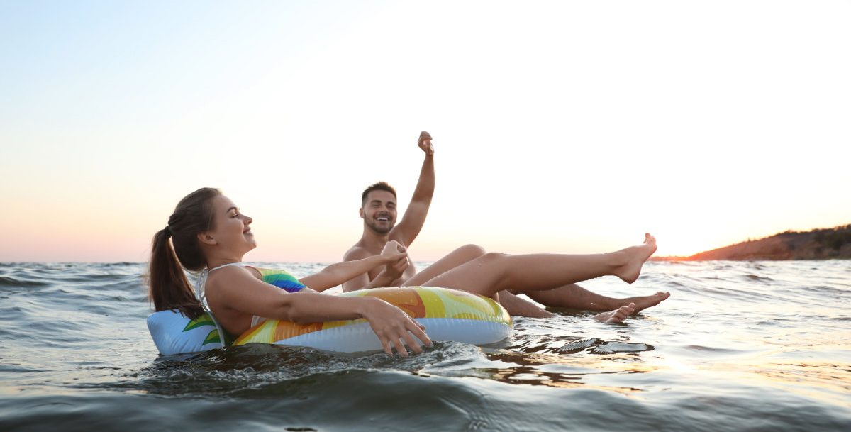 couple on tubes in water