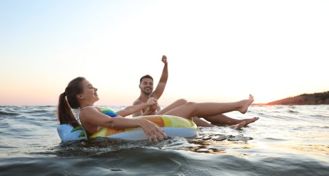 couple on tubes in water